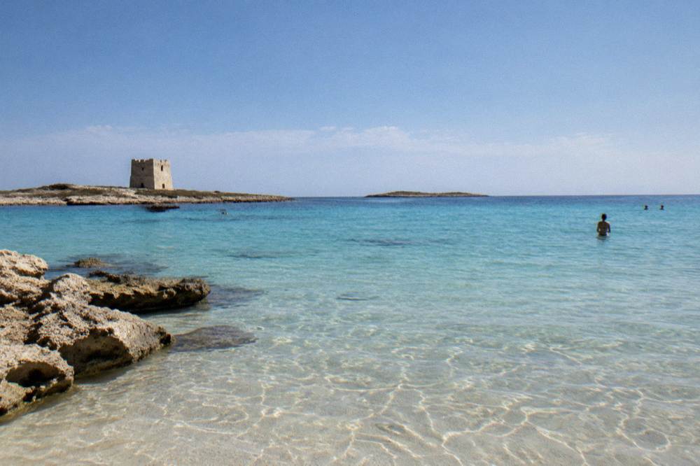 Shallow clear green-blue water over pale sand